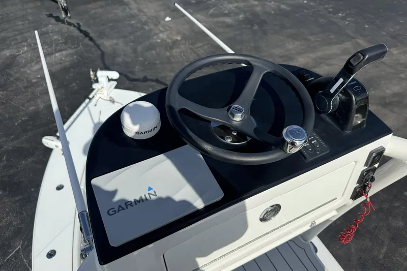 Slide: The Image of 2018 Jupiter 25 Bay boat helm with Garmin navigation system and steering wheel. - 6
