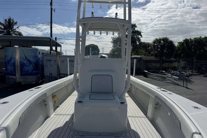 Slide: The Image of 2018 Jupiter 25 Bay boat interior with seating and console, parked outdoors. - 4
