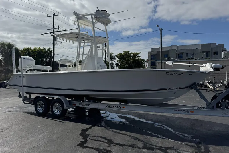The Image of 2018 Jupiter 25 Bay boat on trailer, parked outdoors under cloudy sky. - 0