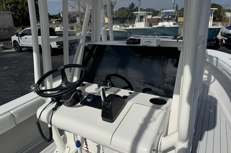 Slide: The Image of 2018 Jupiter 25 Bay boat console with steering wheel and controls. - 3