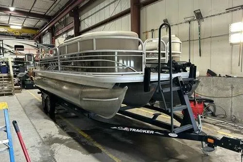 The Image of 2022 Sun Tracker SportFish 22 XP3 pontoon boat in a warehouse setting. - 1