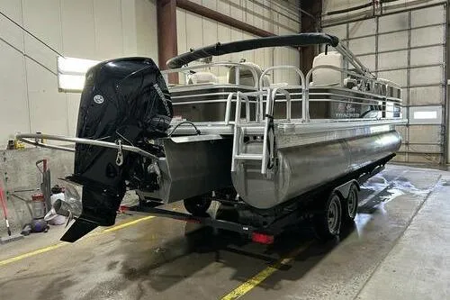 Slide: The Image of 2022 Sun Tracker SportFish 22 XP3 pontoon boat in a garage setting. - 3