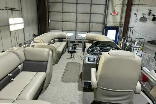 Slide: The Image of 2022 Sun Tracker SportFish 22 XP3 pontoon boat interior with beige seating and steering console. - 10