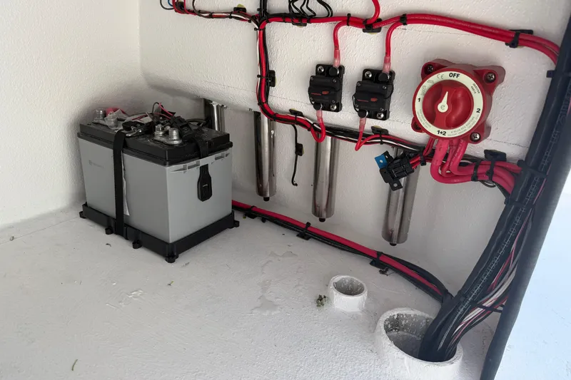 Slide: The Image of Electrical setup in a 2026 Skuta 24 Cat boat, featuring battery and wiring. - 54