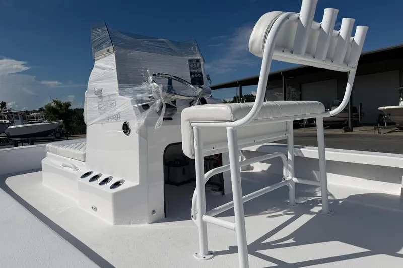 Slide: The Image of 2026 Skuta 24 Cat boat with white seating and console, wrapped for protection. - 7