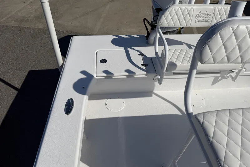 Slide: The Image of 2026 Skuta 24 Cat boat interior with white quilted seating and deck details. - 48