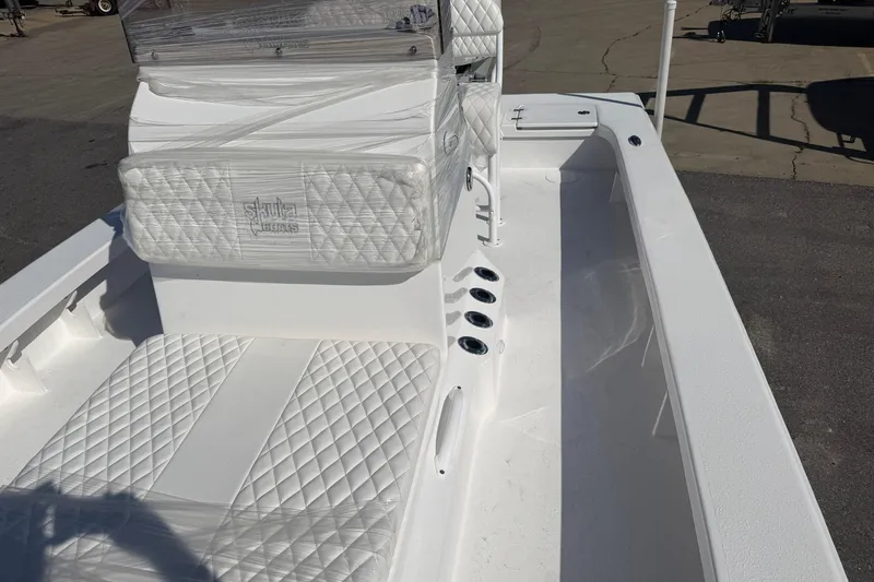 Slide: The Image of 2026 Skuta 24 Cat boat interior with quilted white seating and sleek design. - 44