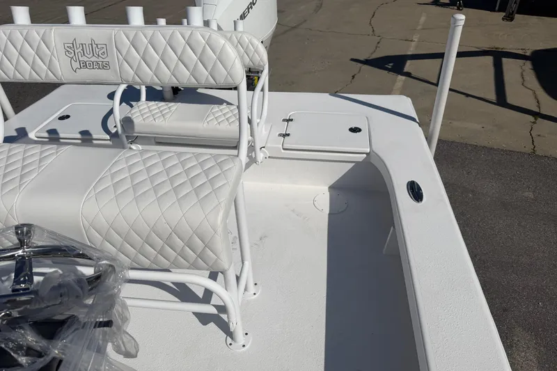 Slide: The Image of 2026 Skuta 24 Cat boat interior with quilted white seating and storage compartment. - 45