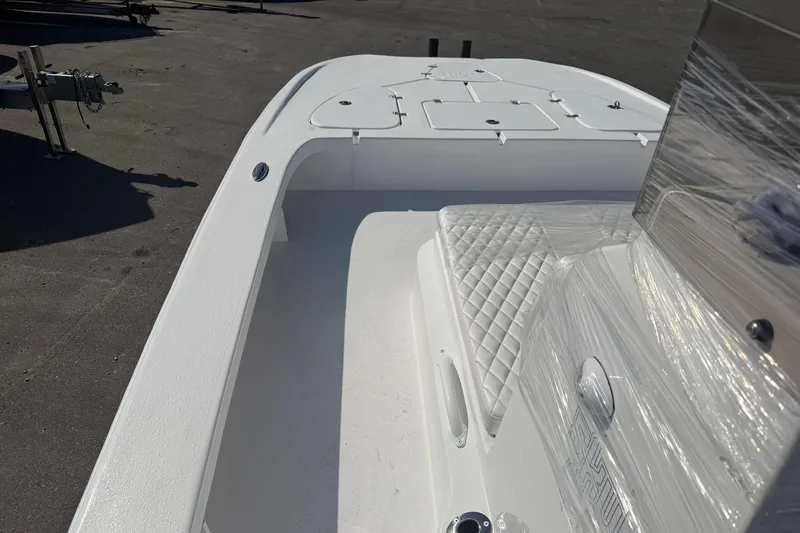 Slide: The Image of 2026 Skuta 24 Cat boat interior with white seating and storage compartments. - 33