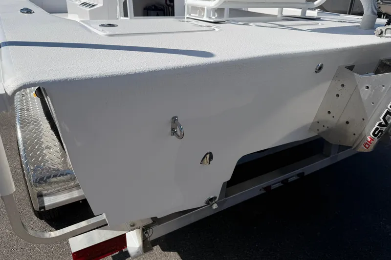 Slide: The Image of 2026 Skuta 24 Cat boat rear view with metal fixtures and trailer. - 27
