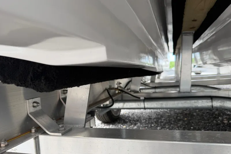 Slide: The Image of Underside view of 2026 Skuta 24 Cat boat trailer, showcasing metal framework. - 60