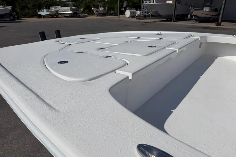 Slide: The Image of 2026 Skuta 24 Cat boat deck with storage compartments, parked outdoors. - 11