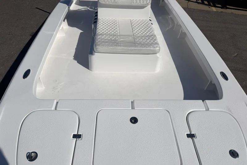 Slide: The Image of 2026 Skuta 24 Cat boat interior with white seating and storage compartments. - 39