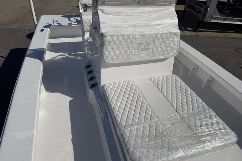Slide: The Image of 2026 Skuta 24 Cat boat interior with wrapped, quilted seats and rod holders. - 43