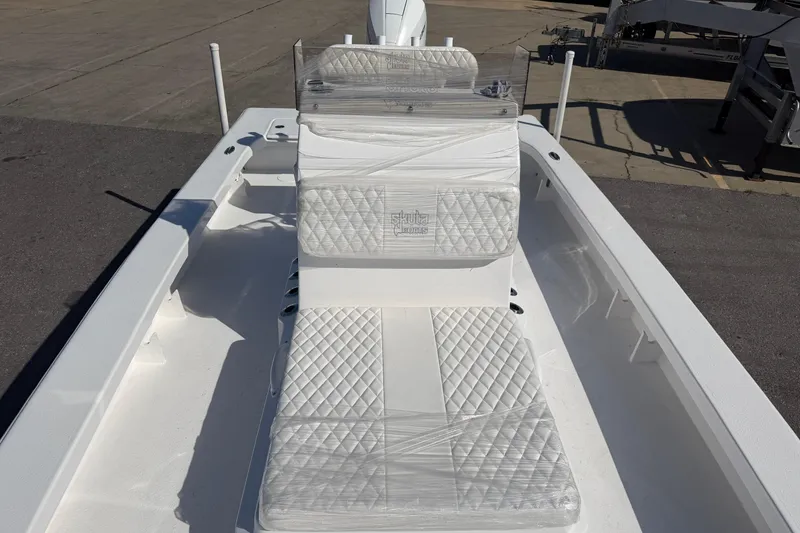 Slide: The Image of 2026 Skuta 24 Cat boat with quilted seating, docked on a sunny day. - 41