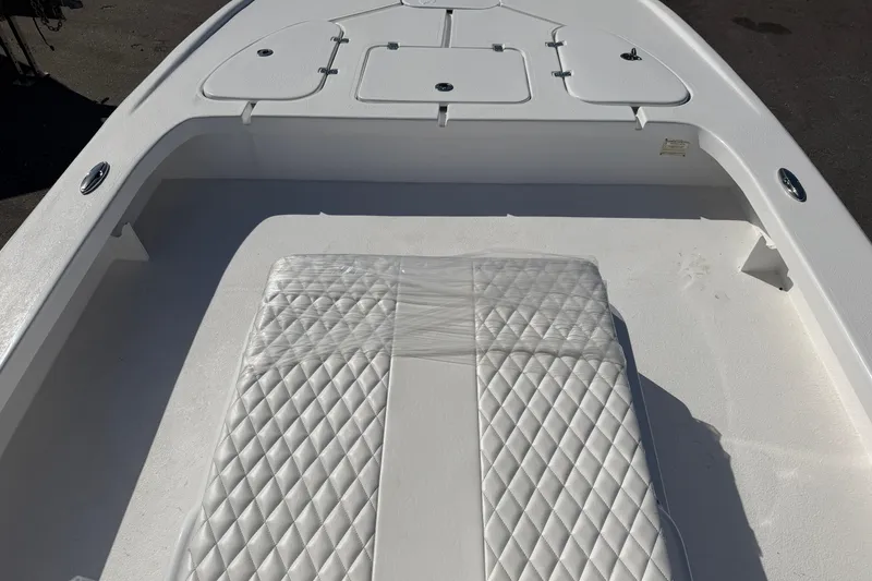 Slide: The Image of 2026 Skuta 24 Cat boat interior with diamond-stitched seating and storage compartments. - 32