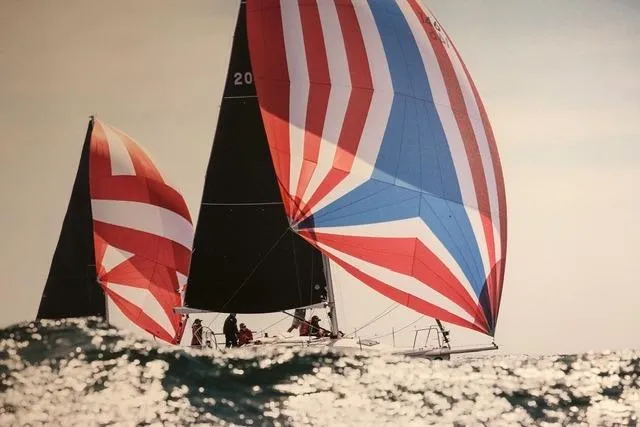 Slide: The Image of Sailboats with colorful spinnakers racing on the ocean, featuring a 2004 J Boats J/109. - 12
