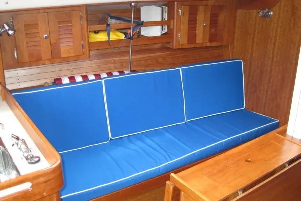 Slide: The Image of Interior of 2005 J Boats J/109 sailboat with blue cushioned seating and wooden cabinetry. - 26