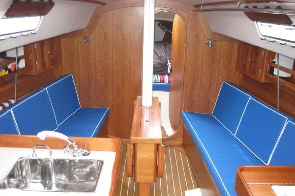 Slide: The Image of Interior of 2005 J Boats J/109 sailboat with blue seating and wooden finishes. - 24