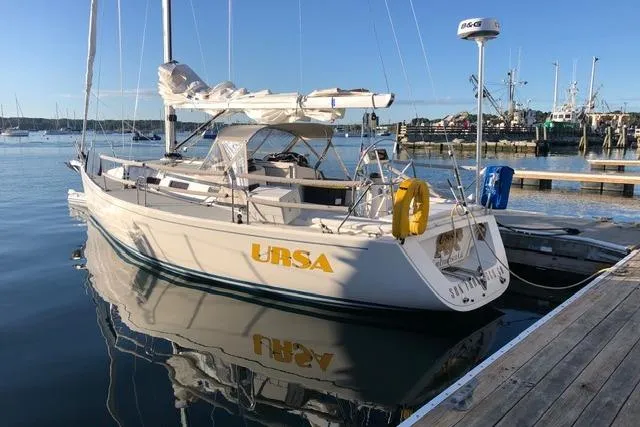 Slide: The Image of 2004 J Boats J/109 sailboat docked in a marina, reflecting on calm water. - 6