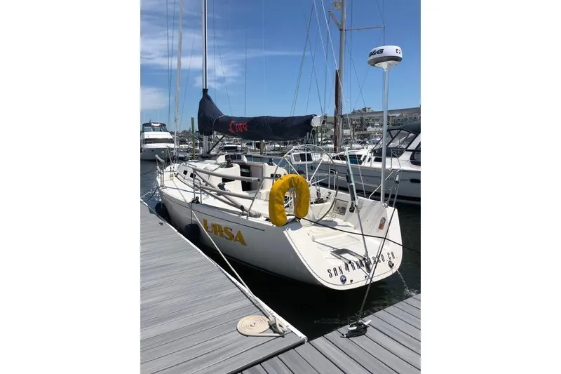 Slide: The Image of 2004 J Boats J/109 sailboat docked at marina, featuring sleek design and yellow life ring. - 23