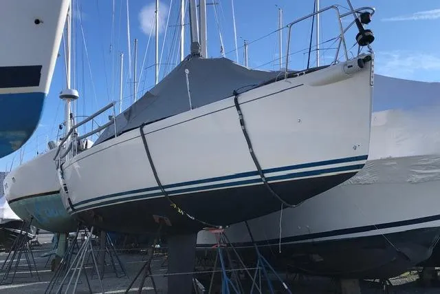 Slide: The Image of 2004 J Boats J/109 sailboat on stands, covered, in a marina setting. - 14