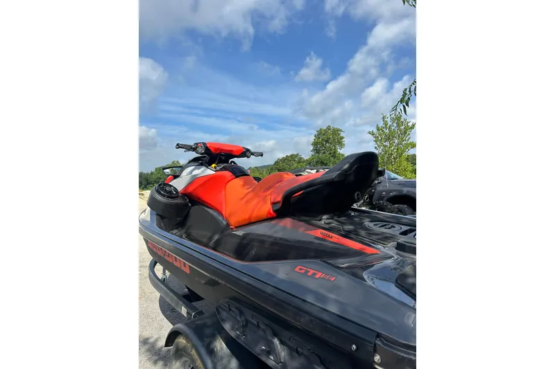 Slide: The Image of 2022 Sea-Doo GTI SE 130 jet ski with vibrant red seat, parked outdoors. - 9