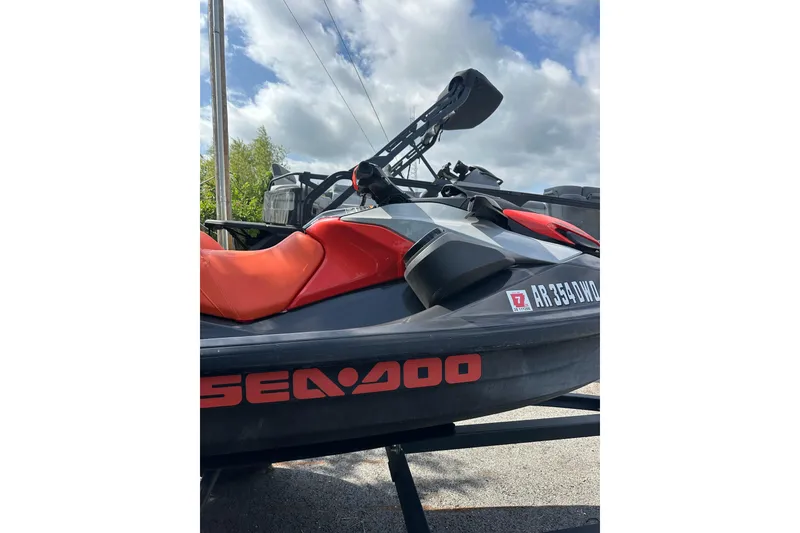 Slide: The Image of 2022 Sea-Doo GTI SE 130 jet ski with vibrant orange seat, parked outdoors. - 6