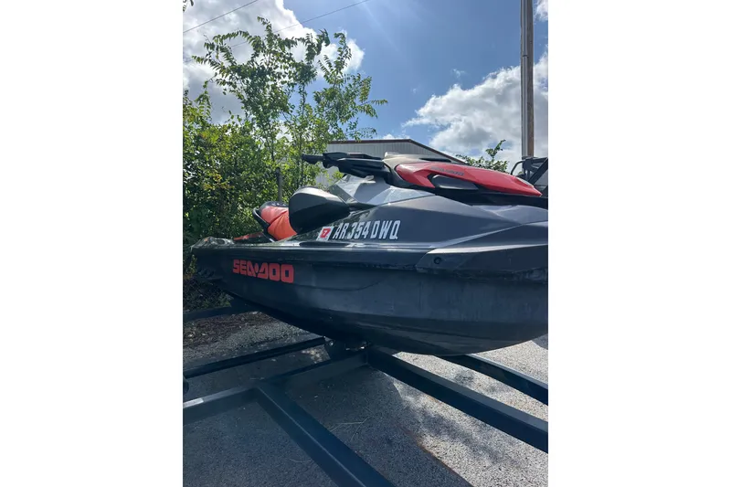Slide: The Image of 2022 Sea-Doo GTI SE 130 jet ski on trailer, parked outdoors under a sunny sky. - 8