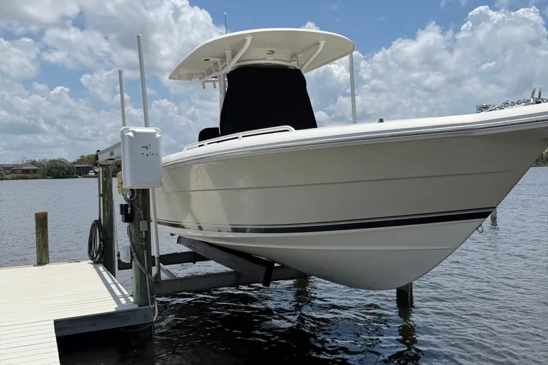 Slide: The Image of 2017 Stamas 317 Tarpon boat on lift by dock, under a partly cloudy sky. - 68
