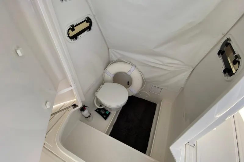 Slide: The Image of Interior of 2017 Stamas 317 Tarpon boat bathroom with toilet and portholes. - 58