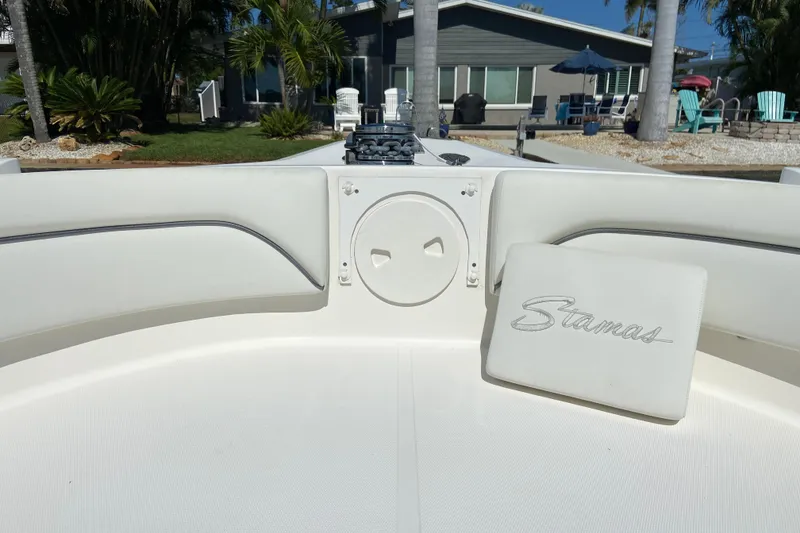 Slide: The Image of 2017 Stamas 317 Tarpon boat interior with seating and logo, docked near a house. - 52