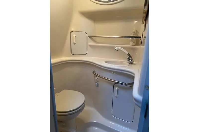 Slide: The Image of 2001 Sea Ray 340 Sundancer bathroom with toilet, sink, and storage cabinets. - 20