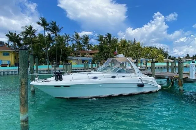 Slide: The Image of 2001 Sea Ray 340 Sundancer docked in tropical marina with palm trees and clear blue water. - 2