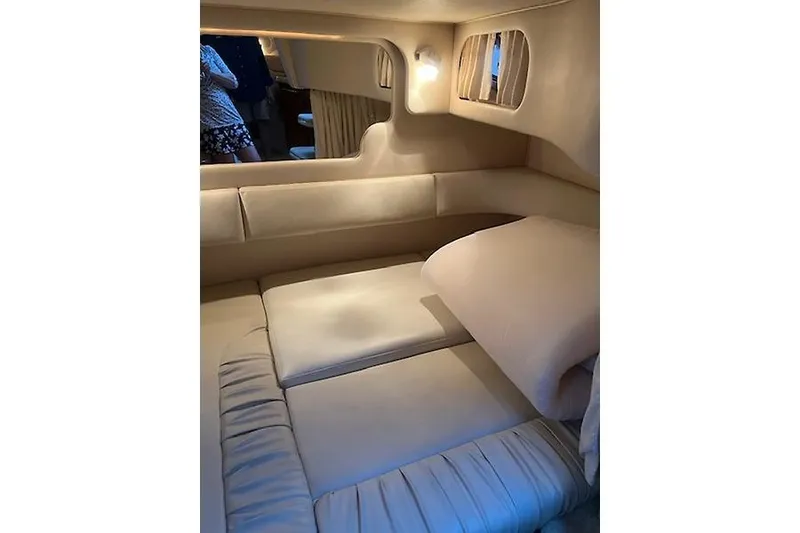 Slide: The Image of Interior cabin of 2001 Sea Ray 340 Sundancer, featuring cozy beige seating and ambient lighting. - 13