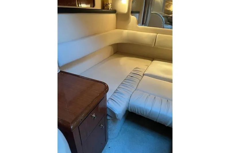 Slide: The Image of Interior cabin of 2001 Sea Ray 340 Sundancer with beige seating and wooden cabinet. - 10