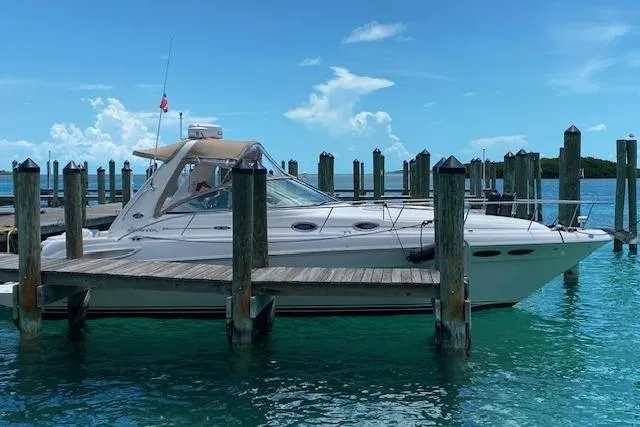 The Image of 2001 Sea Ray 340 Sundancer docked in clear turquoise water under a bright blue sky. - 0