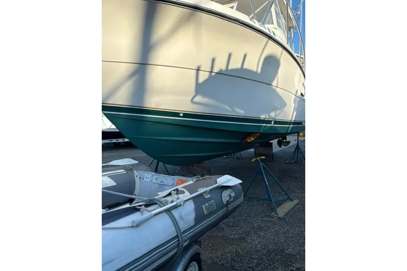 Slide: The Image of 1996 Pursuit 3000 Offshore boat on stands, with inflatable dinghy in foreground. - 17