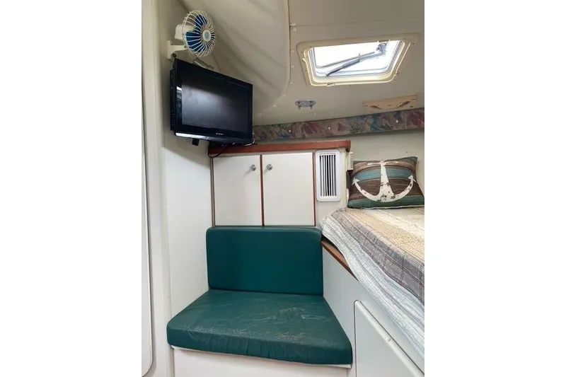 Slide: The Image of Interior of a 1996 Pursuit 3000 Offshore boat with seating, TV, and bed. - 9