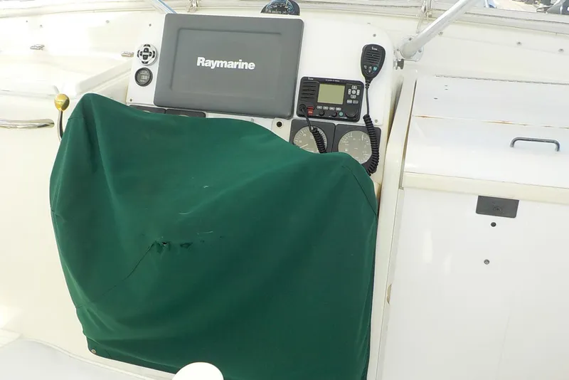 Slide: The Image of 1996 Pursuit 3000 Offshore boat dashboard with Raymarine equipment and green cover. - 6