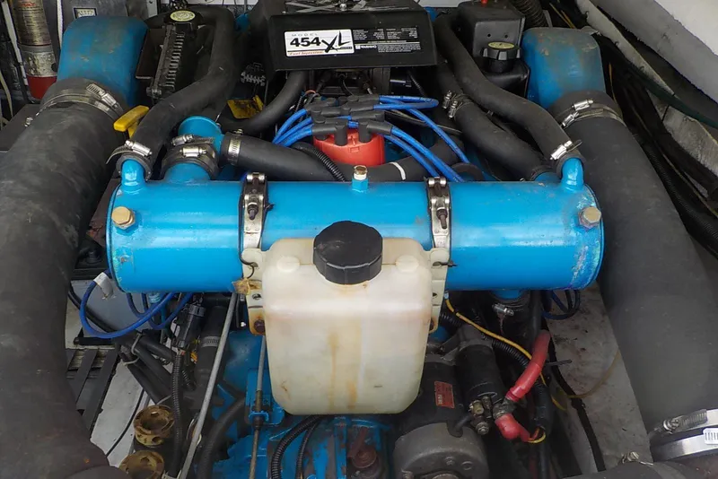 Slide: The Image of Engine of a 1996 Pursuit 3000 Offshore boat, featuring blue components and hoses. - 21