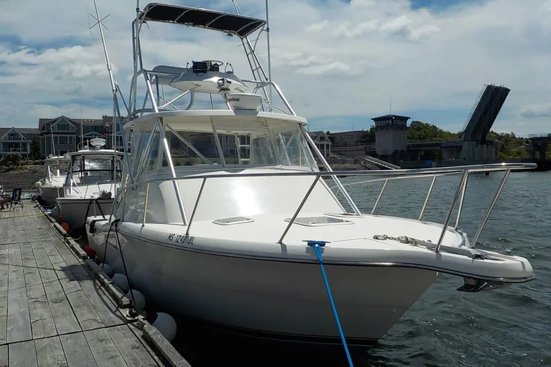 Slide: The Image of 1996 Pursuit 3000 Offshore boat docked near a drawbridge on a sunny day. - 2
