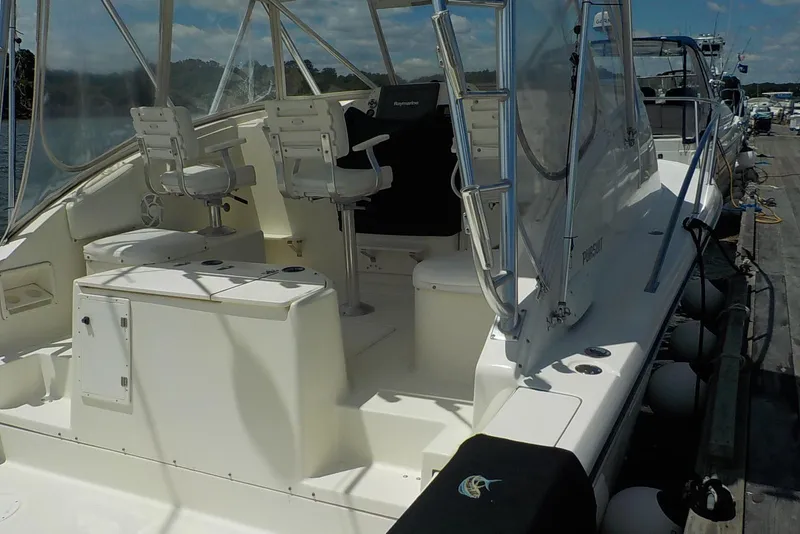 Slide: The Image of 1996 Pursuit 3000 Offshore boat docked, featuring spacious seating and fishing amenities. - 3