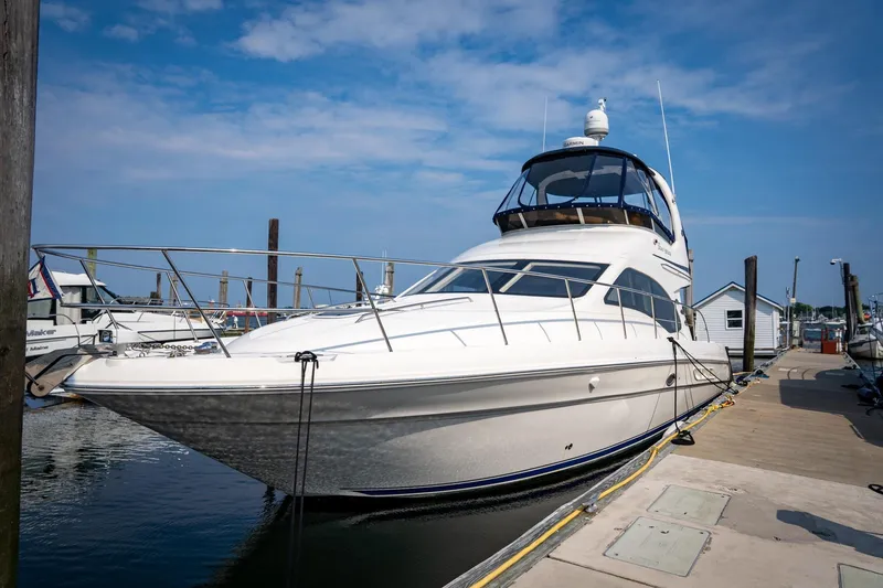 The Image of 2006 Sea Ray 44 Sedan Bridge yacht docked at marina under clear blue sky. - 0