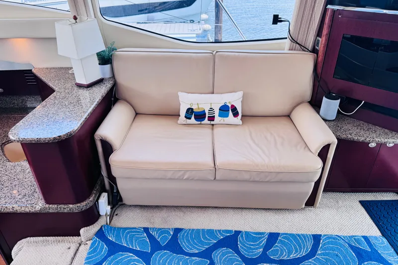 Slide: The Image of Luxurious interior of 2006 Sea Ray 44 Sedan Bridge with beige sofa and nautical decor. - 19