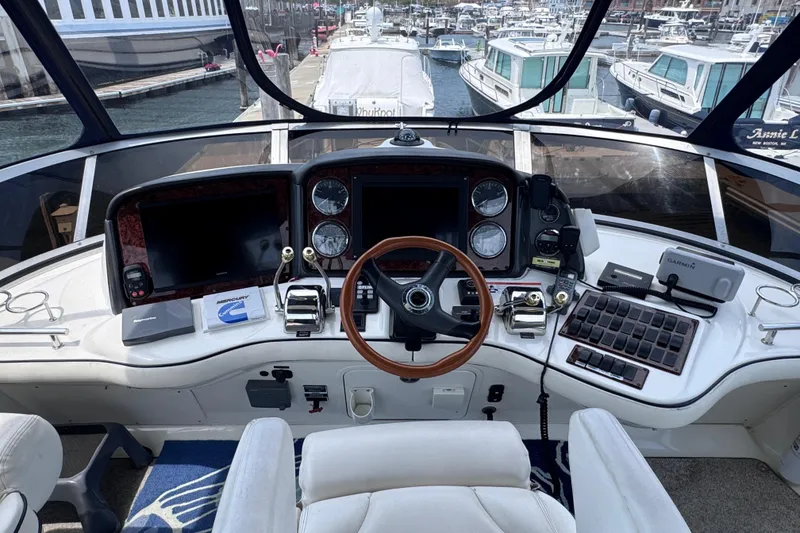 Slide: The Image of Cockpit of 2006 Sea Ray 44 Sedan Bridge yacht with navigation controls and marina view. - 28