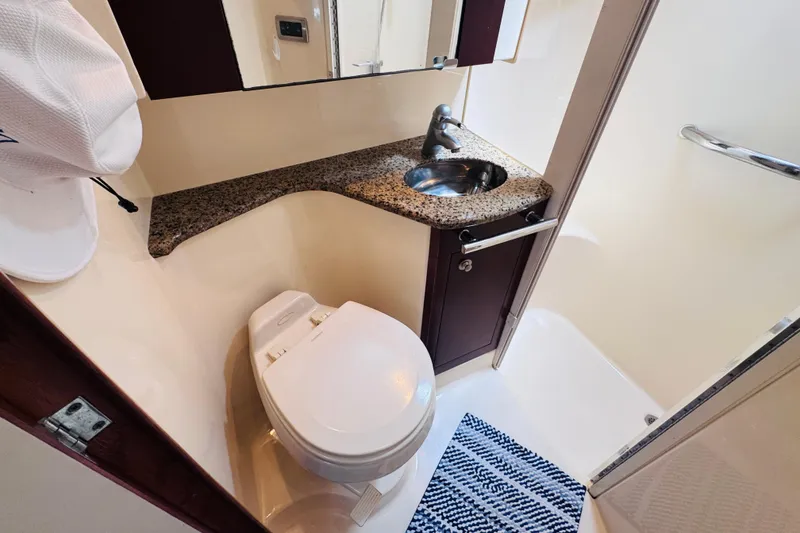 Slide: The Image of Bathroom interior of 2006 Sea Ray 44 Sedan Bridge with granite countertop and compact design. - 8