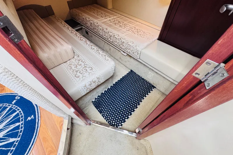 Slide: The Image of Interior cabin of 2006 Sea Ray 44 Sedan Bridge with twin beds and nautical decor. - 11