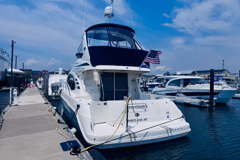 Slide: The Image of 2006 Sea Ray 44 Sedan Bridge yacht docked at marina, Portland, ME, under clear blue sky. - 2