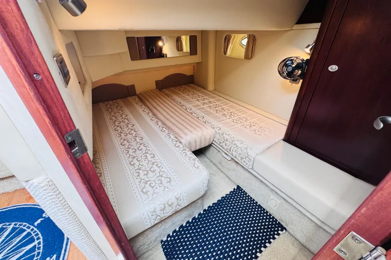 Slide: The Image of 2006 Sea Ray 44 Sedan Bridge cabin with twin beds, elegant decor, and cozy lighting. - 12